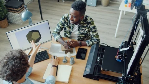 High angle view of man and woman working in office using 3d printer and computer Stock Footage 119555785