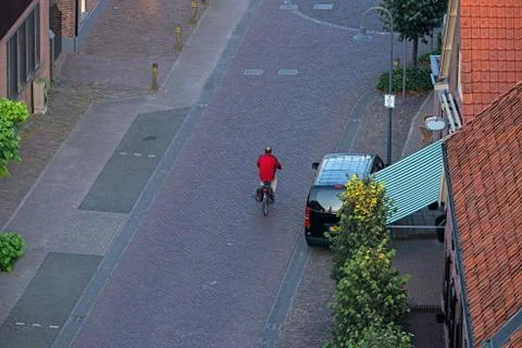 High angle view of man on bicycle in street of dutch rural village. Stock Photos