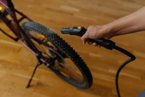 High-angle view of man cleaning bicycle tire with steam cleaner, removing dirt Stock Photos