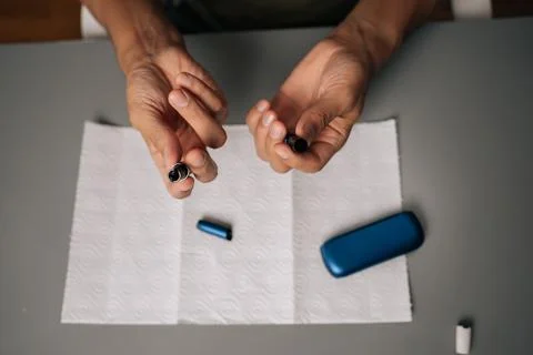 High-angle view of man cleaning electronic cigarette emphasizing importance of Stock Photos