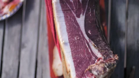 High angle view of man hand cutting a slice of spanish jamon serrano on table. 스톡 동영상 152246625