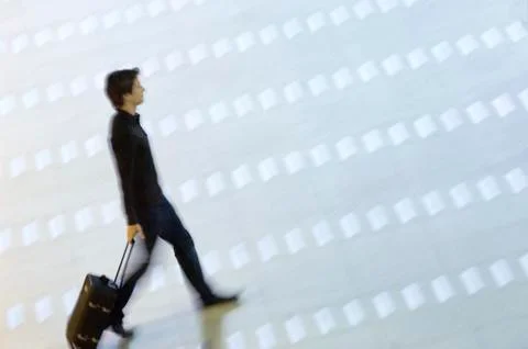 High angle view of a man pulling his luggage at an airport lobby Stock Photos