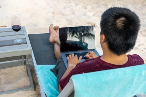 High angle view of man typing laptop keyboard on beach Foto stock