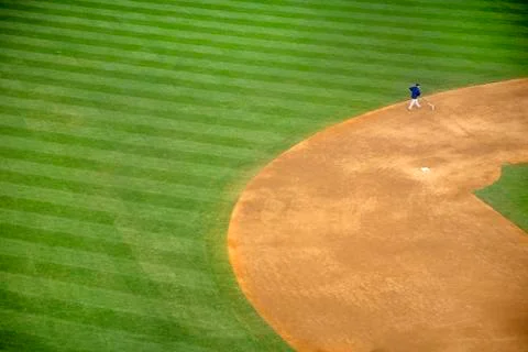 High angle view of man walking on baseball field near second base. Stock Photos