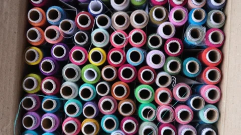 High angle view of many colorful sewing thread spools organized Видео 329370247