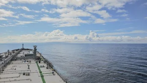 High angle view of a massive cargo ship deck sailing through calm blue ocea.. Stock Photos