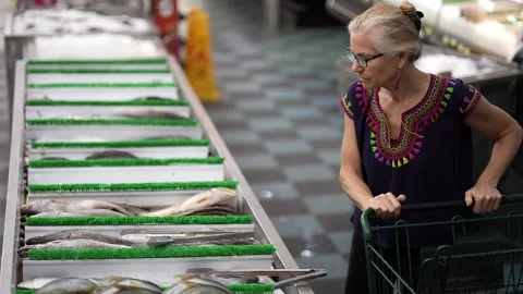 High angle view of mature attractive woman pushing shopping cart look at fish Stock Footage 277713612