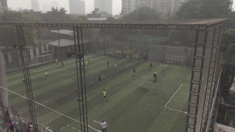High Angle View of Men Playing Soccer Match on Artificial Turf Under Hazy City Vidéo 336131119