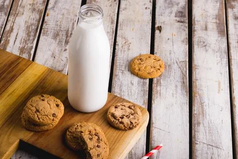 High angle view of milk bottle with cookies on wooden table, copy space Stock Photos