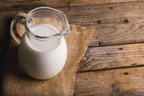 High angle view of milk in jar with burlap on table, copy space Stock Photos