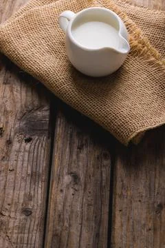 High angle view of milk in jug with burlap on table, copy space Stock Photos
