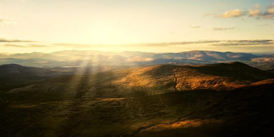 High angle view of mountain ranges and hills illuminated by sun rays Stock Photos