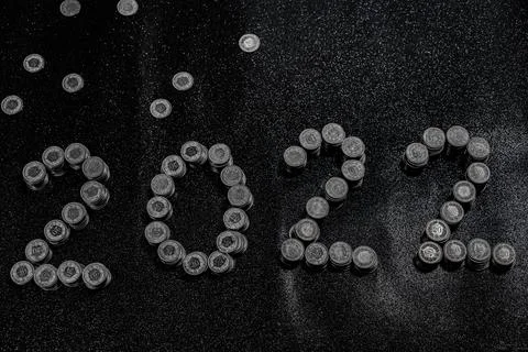 High angle view of New Years 2022 as Swiss coins on a black shiny background. Stock Photos