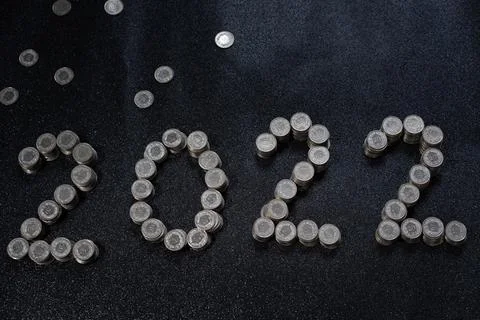 High angle view of New Years 2022 as Swiss coins on a black shiny background. Stock Photos