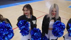 A cheerleader shakes her pom-poms smiles and encourages action