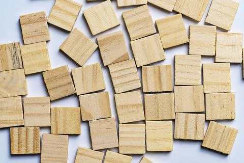 High-angle view of numerous empty, natural wood square tiles scattered rand.. Stock Photos
