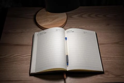 High angle view of an open blank notebook and pen on wooden desk. Stock Photos