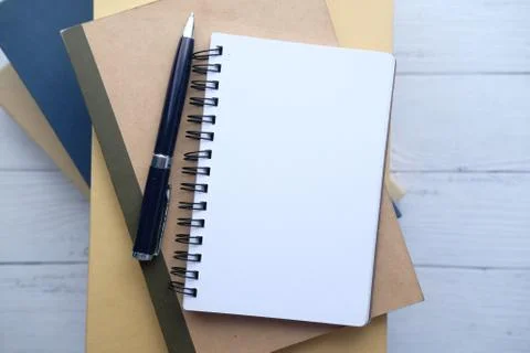 High angle view of open notepad on stack of books Stock Photos