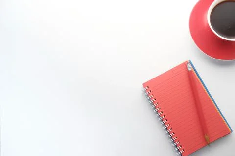 High angle view of open notepad, tea and pencil on white background Stock Photos
