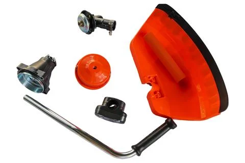 High angle view of orange grass cutter attachment accessories on a white ba.. Stock Photos