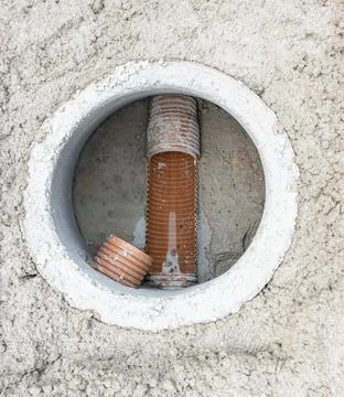 High angle view of orange plastic drainage pipes in a concrete inspection m.. Stock Photos