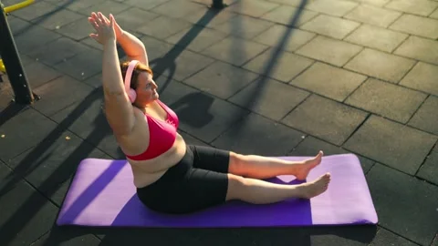 High angle view of an overweight obese woman performing a fitness stretch. Stock Footage 344249563