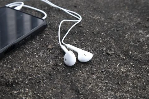 High angle view of a pair of classic white wired earphones plugged into a s.. Stock Photos