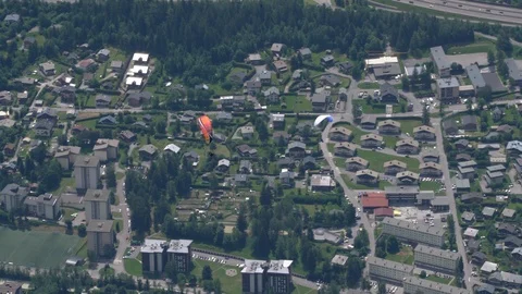 High angle view of paragliders over the alpine town of Chamonix in France Stock Footage 124392823