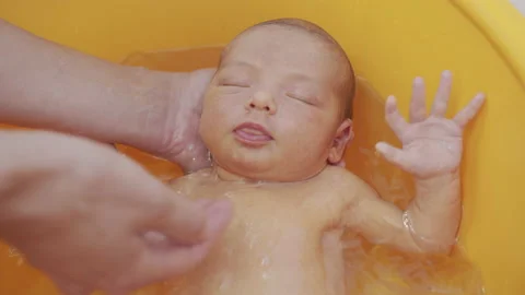 High angle view of parents bathing their newborn baby girl. Stock Footage 133986921