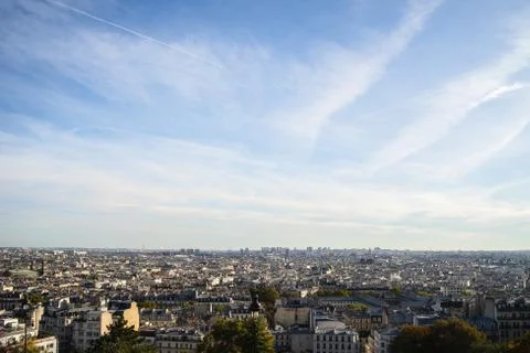 A high angle view of Paris covered in greenery and buildings under sunlight i 스톡 사진