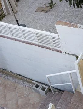 High angle view of patio wall with louvered tiles and outdoor staircase dur.. Stock Photos
