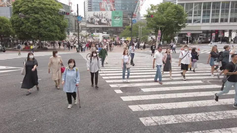 High angle view  . Pedestrians cross at Shibuya Crossing in Tokyo , Japan Stock Footage 244696231