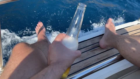High angle view of person sitting on boat deck and holding refreshing drink in Video stock 318649021