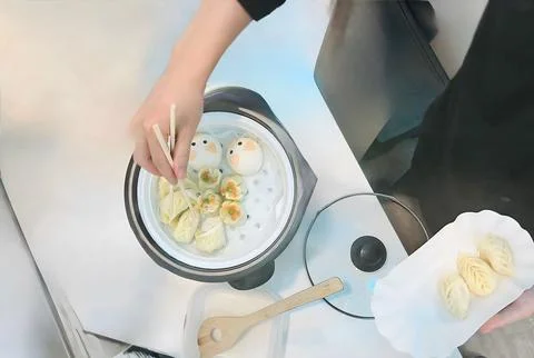 High Angle View of Person Using Chopsticks to Pick Up Steamed Dumplings fro.. Stock-Fotos