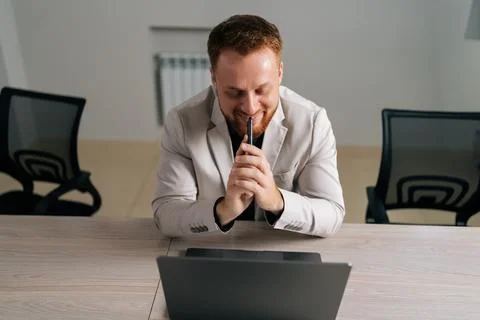 High-angle view portrait of smiling pensive business man holding smartphone Stock-Fotos