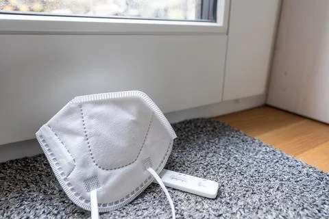 High angle view of positive self test and protective mask on the floor. Stock Photos