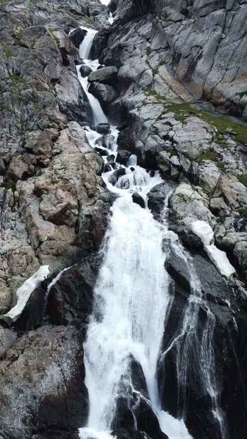 High angle view of powerful multi-tiered waterfall cascading down rocky cliff Stock Footage 336685314