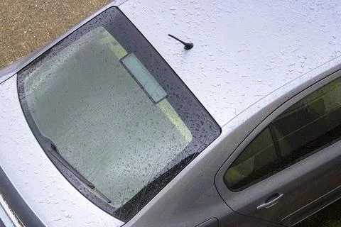 High-Angle View of Raindrops on Silver Car Roof and Rear Windshield Stock Photos