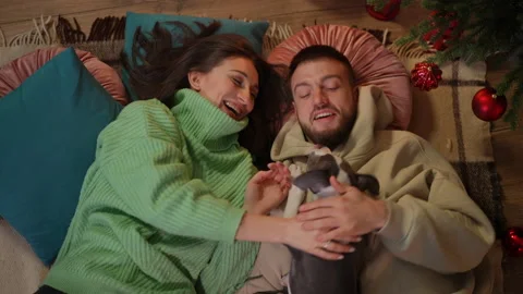 High angle view of relaxed young man and woman talking lying at New Year tree as Stock Footage 219910441