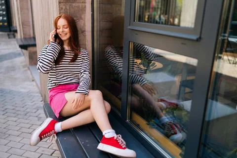 High-angle view of relaxed young woman talking on smartphone while waiting Stock Photos