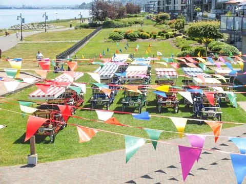 High angle view of rental surrey bikes under colorful festival bunting flag.. Stock Photos