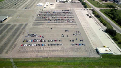 High angle view revealing a huge, almost empty new car parking lot at an au.. Stock-Footage 333602485