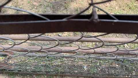A high angle view reveals an aged chain link fence with rusted metal bars and 库存照片