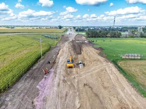 High angle view of a road construction project starting in a corn field and Stock Photos