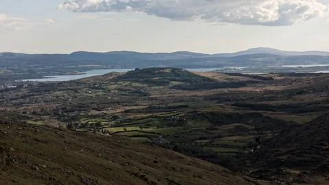 A high angle view of rolling hills, green fields, and a lake Stock Photos