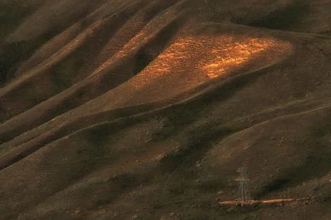 High angle view of rolling hills with a bright patch of golden sunlight and a Stock-Fotos