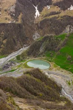 High angle view of round alpine lake in deep mountain valley near Gudauri, Фото
