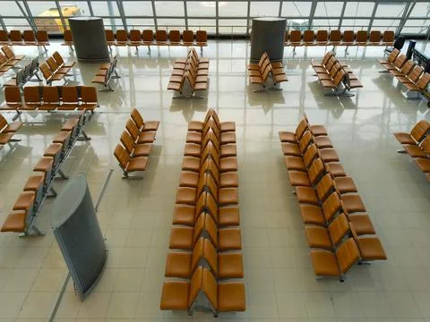 High angle view of rows of empty orange seats in front of gates at airport Stock Photos