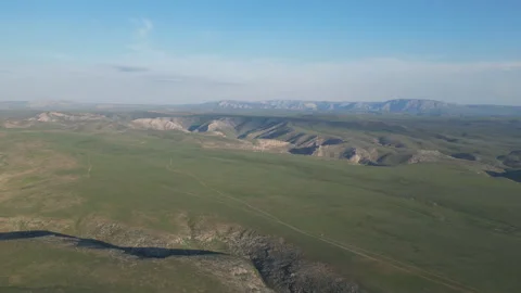 High-angle view of a rugged, green landscape with distant mountain ridges. Stock Footage 334451430
