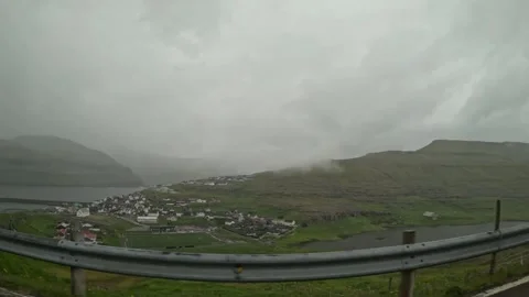 High angle view of Sandur village and lake from a moving car, Faroe Islands Stock Footage 339946595
